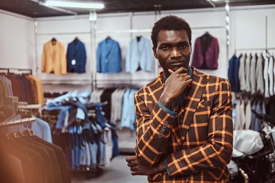 Pensive elegantly dressed african american man posing with h