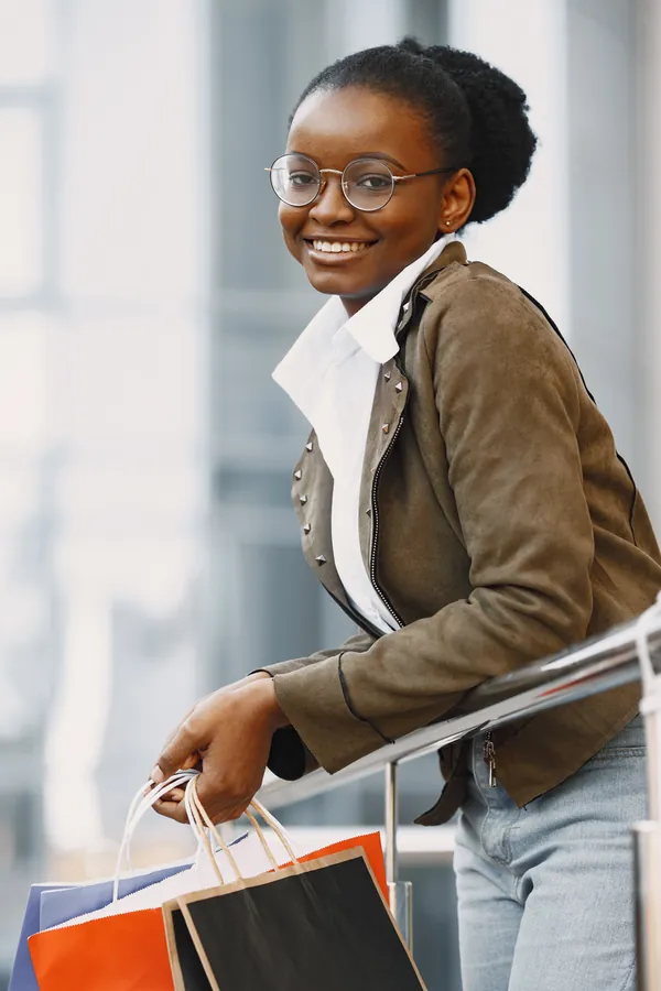 Young attractive woman jacket holding lot shopping packages